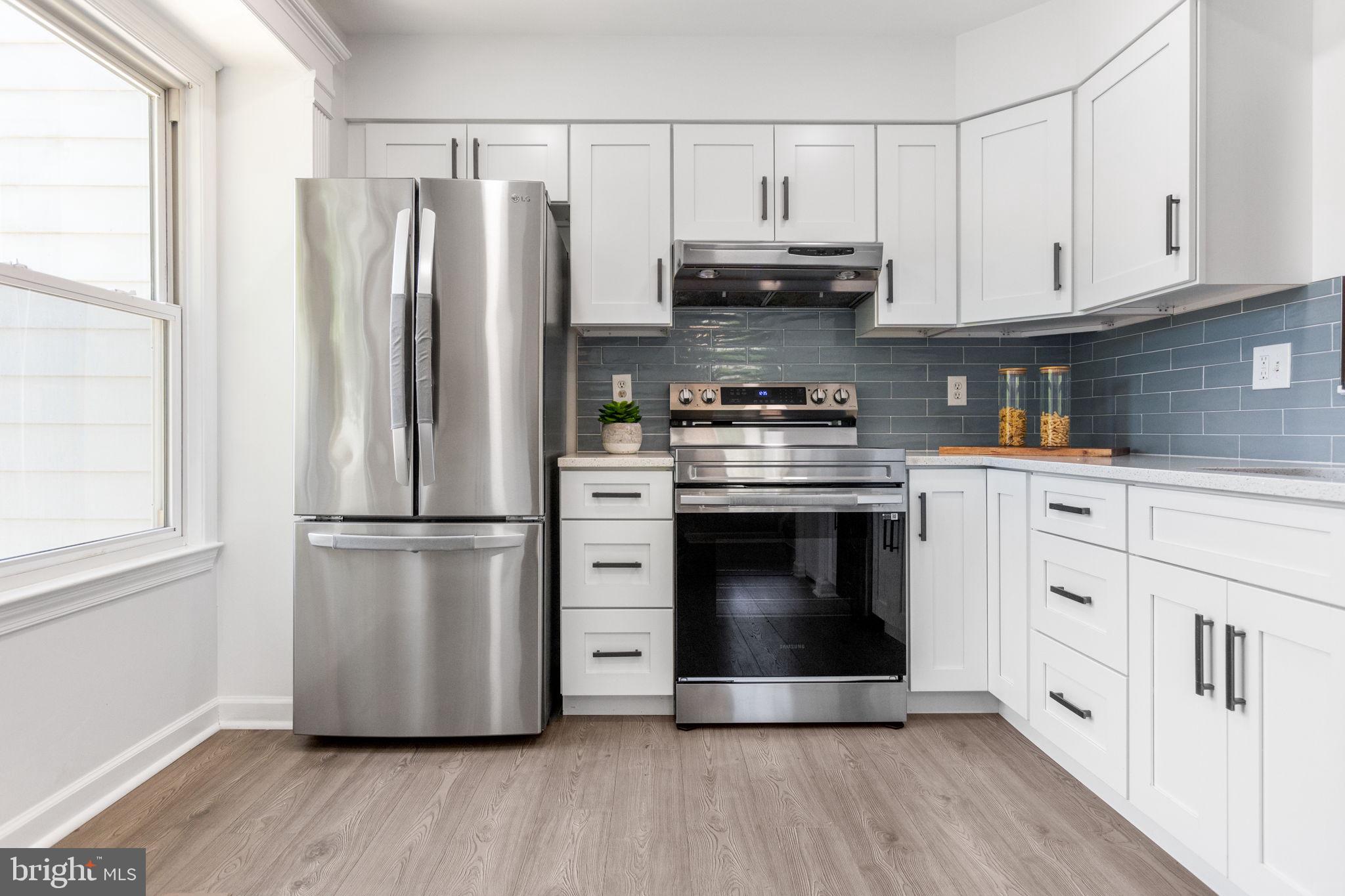 a kitchen with stainless steel appliances a stove a refrigerator and cabinets