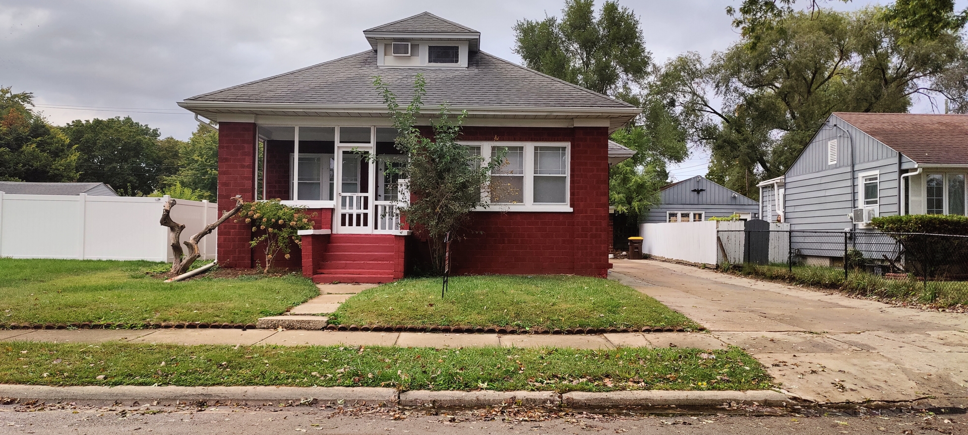 a front view of a house with a yard garden and outdoor seating