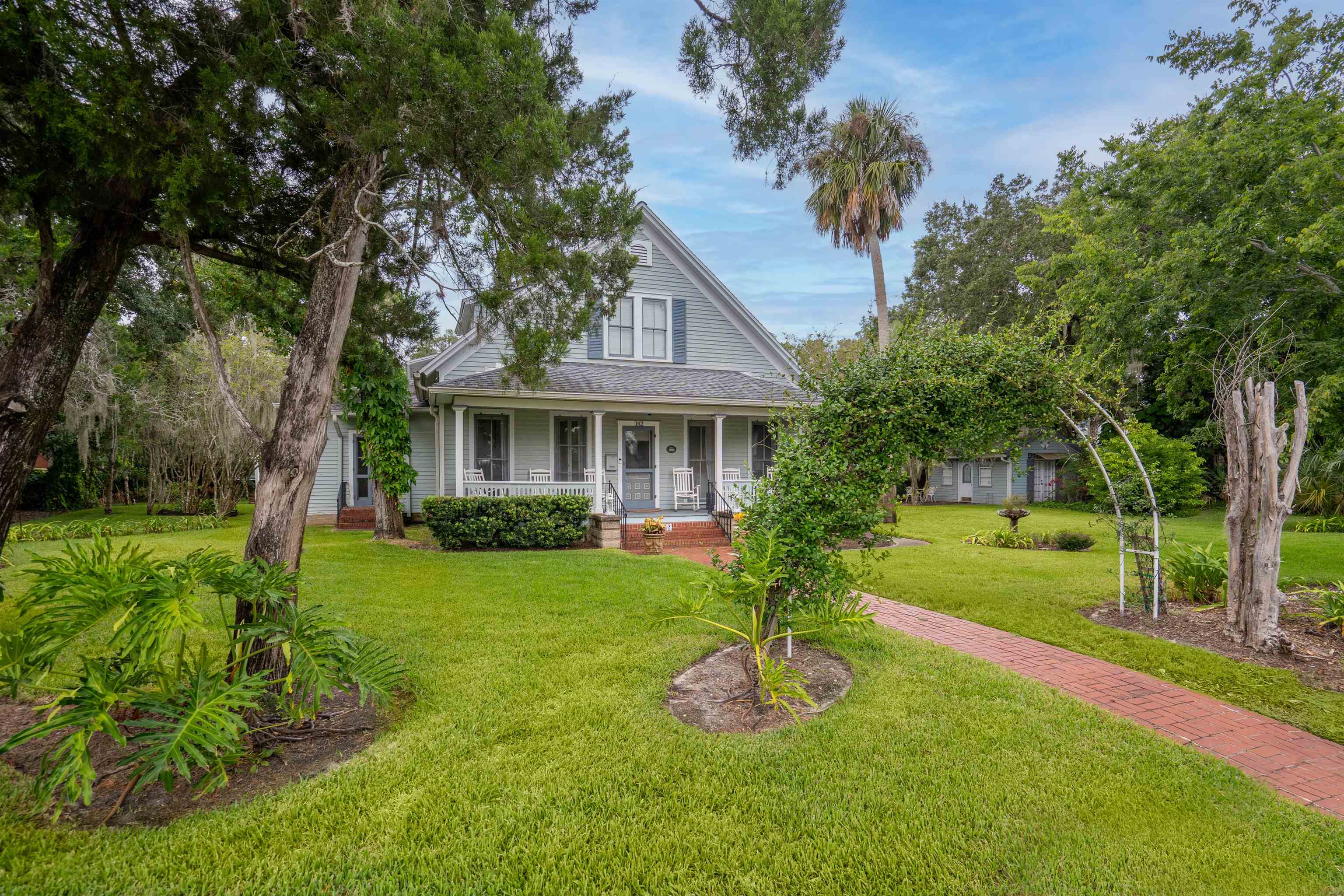 a front view of house with a garden and trees