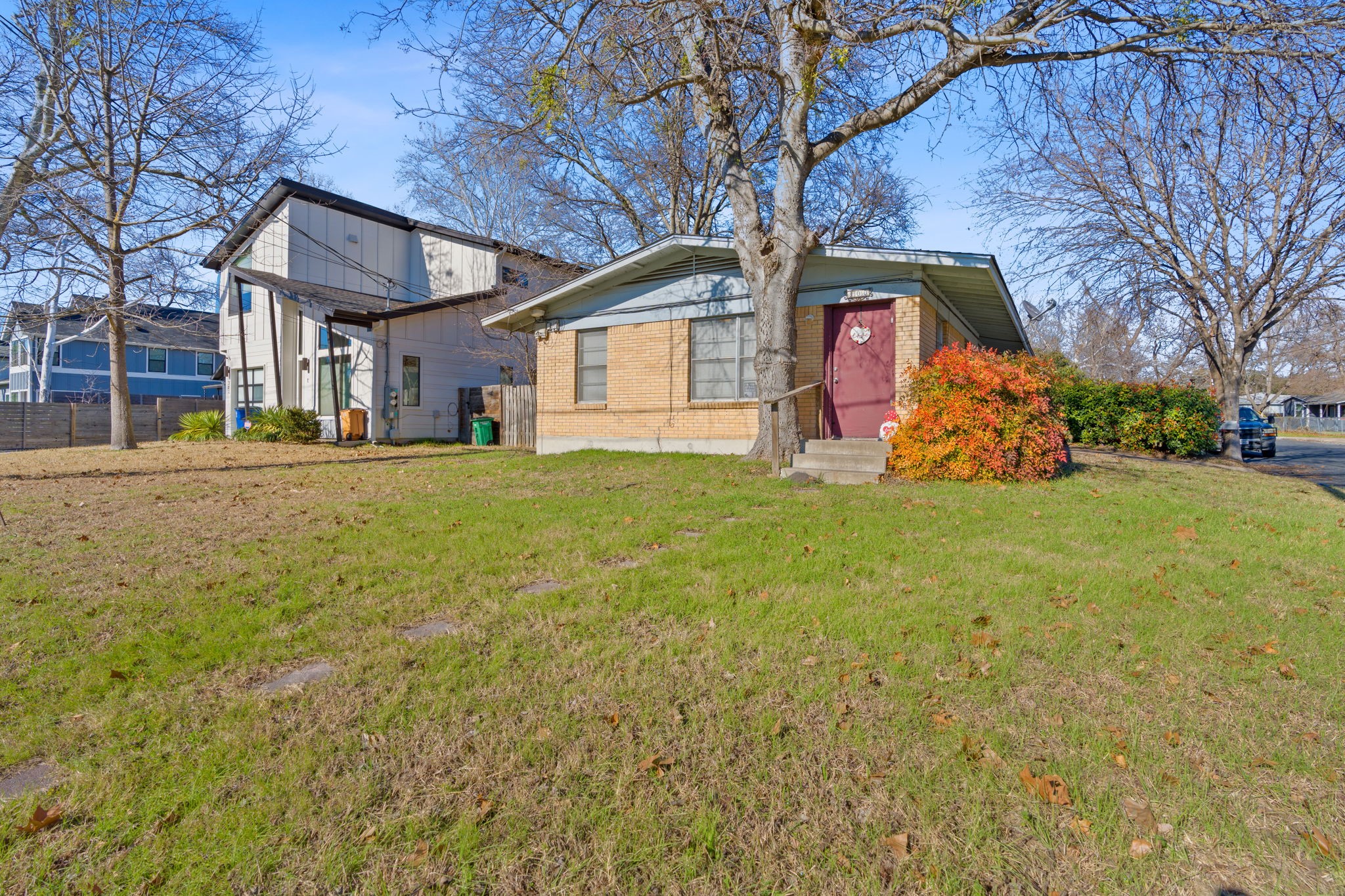 a view of a house with a big yard and large tree