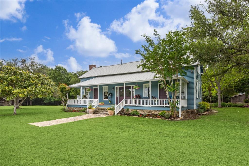 a front view of a house with garden and trees