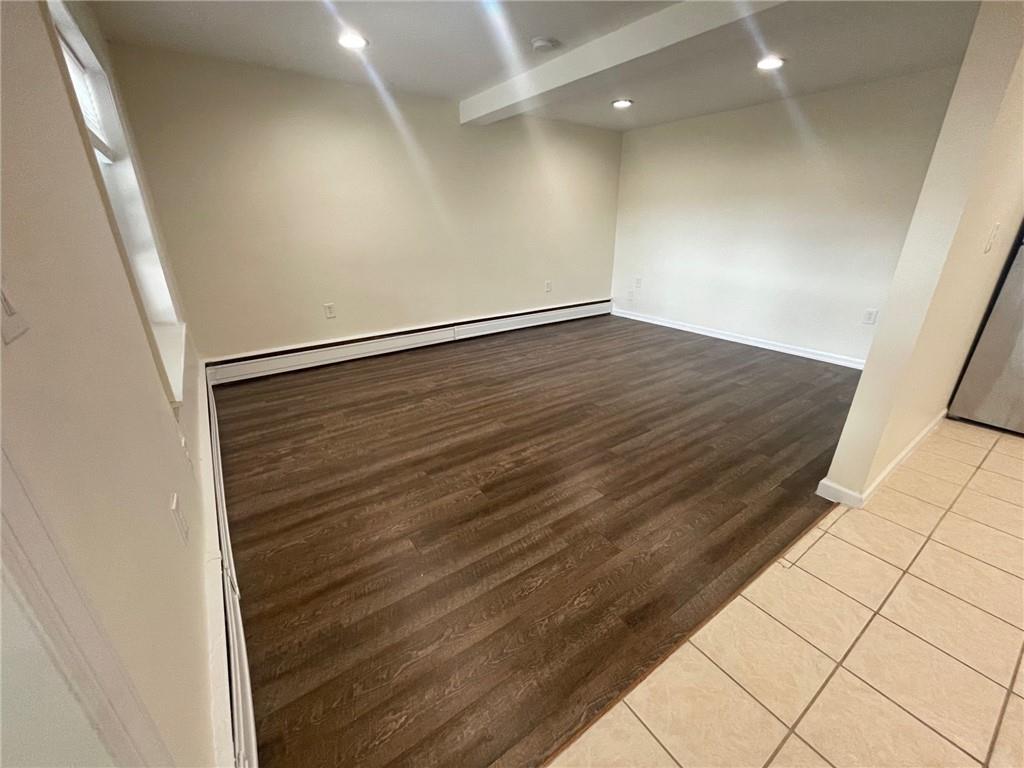 Livingroom with light hardwood / wood-style flooring and a baseboard heating unit