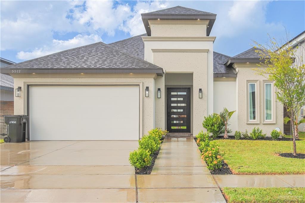 Prairie-style home featuring a garage and a front lawn