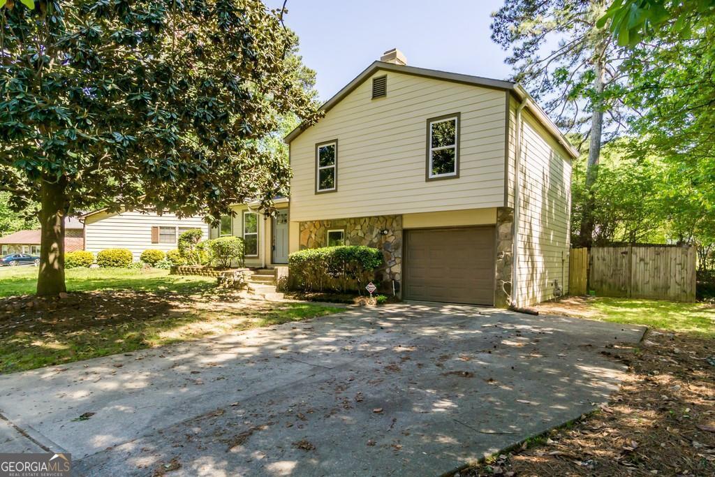 a view of a house with backyard and trees