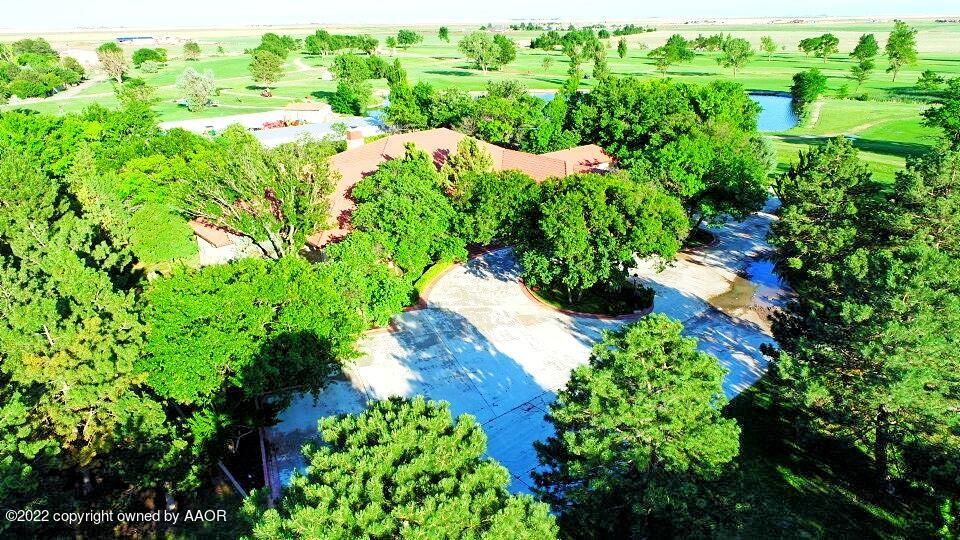 an aerial view of residential house with outdoor space and trees all around