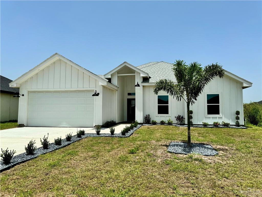 View of front facade with a garage and a front lawn