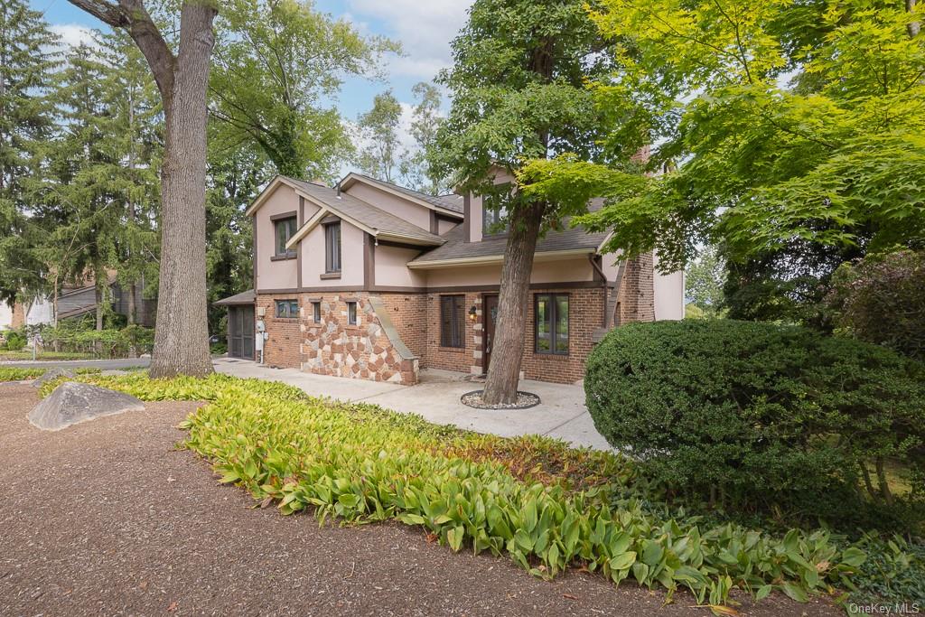 a view of a house with a large tree and a yard in front of it