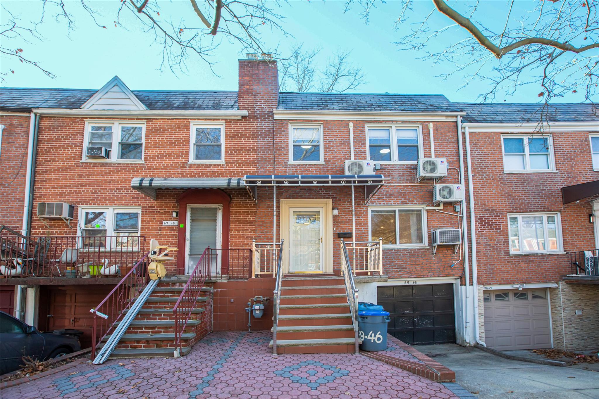 View of front of property featuring ac unit, an AC wall unit, and a garage