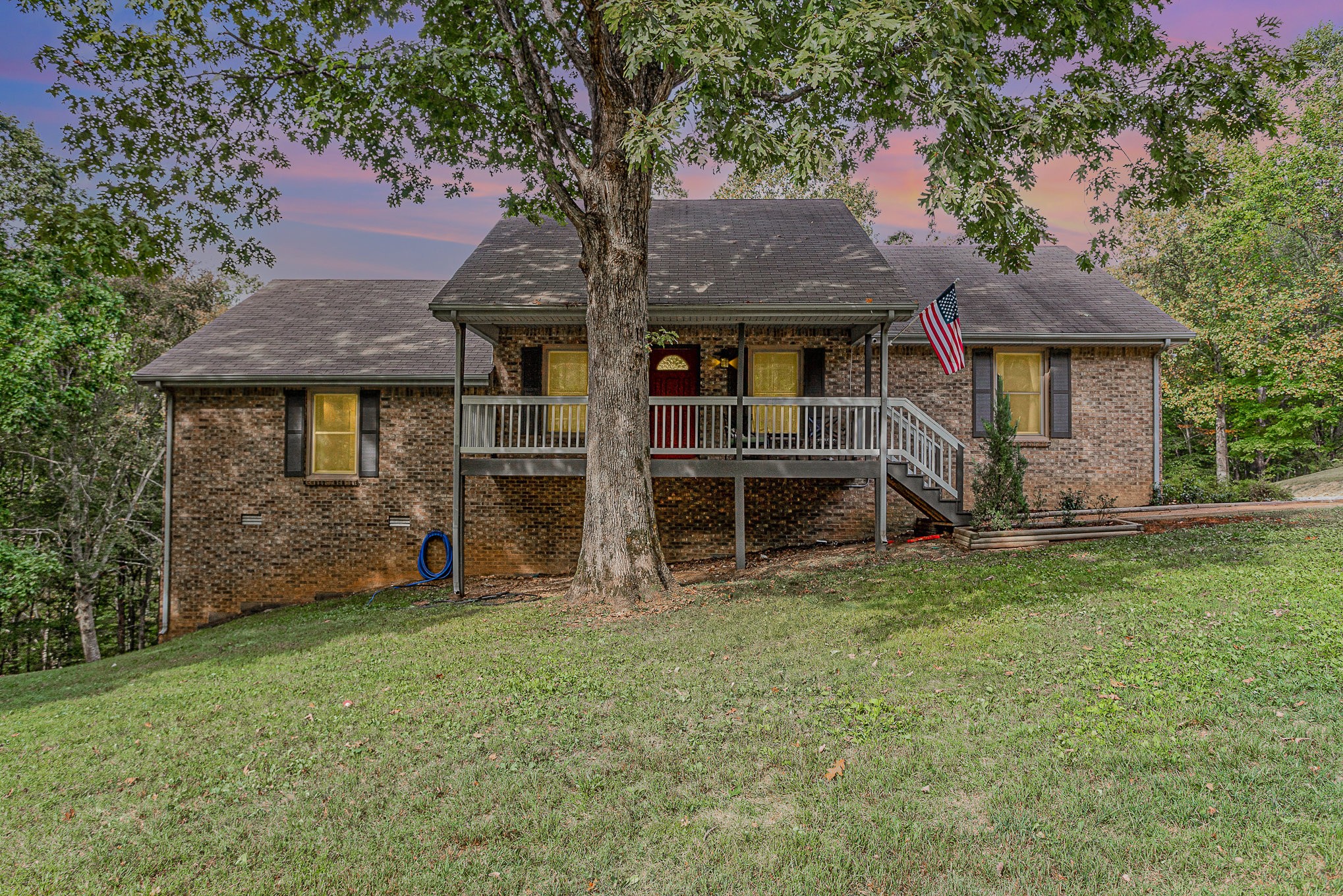 a view of a house with backyard and a tree