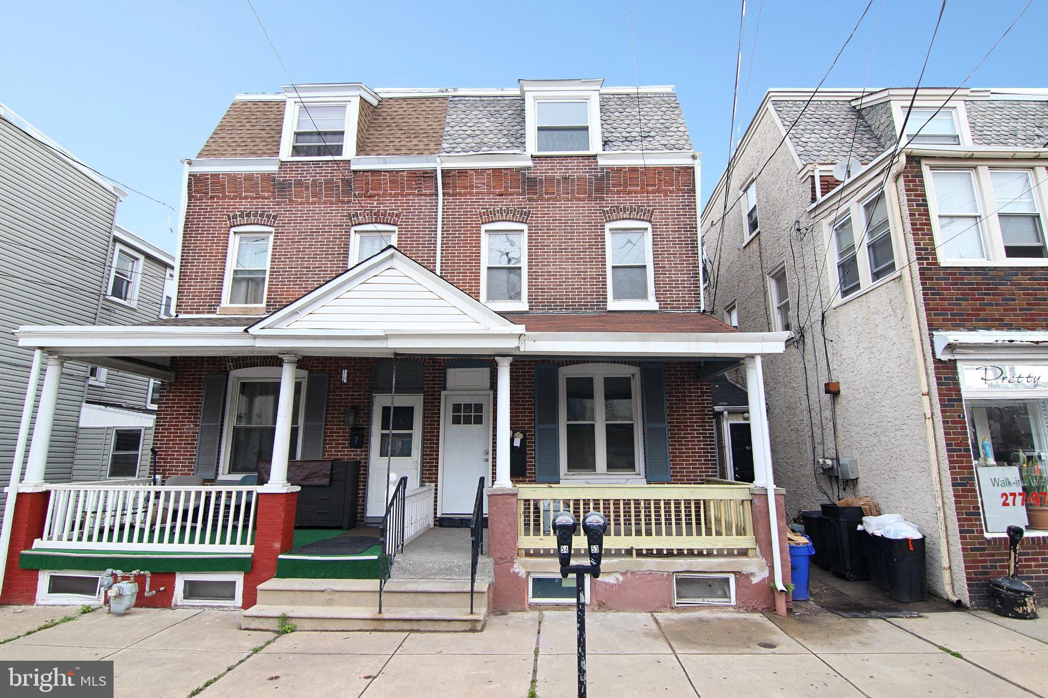 a view of a brick house with a small yard and large window