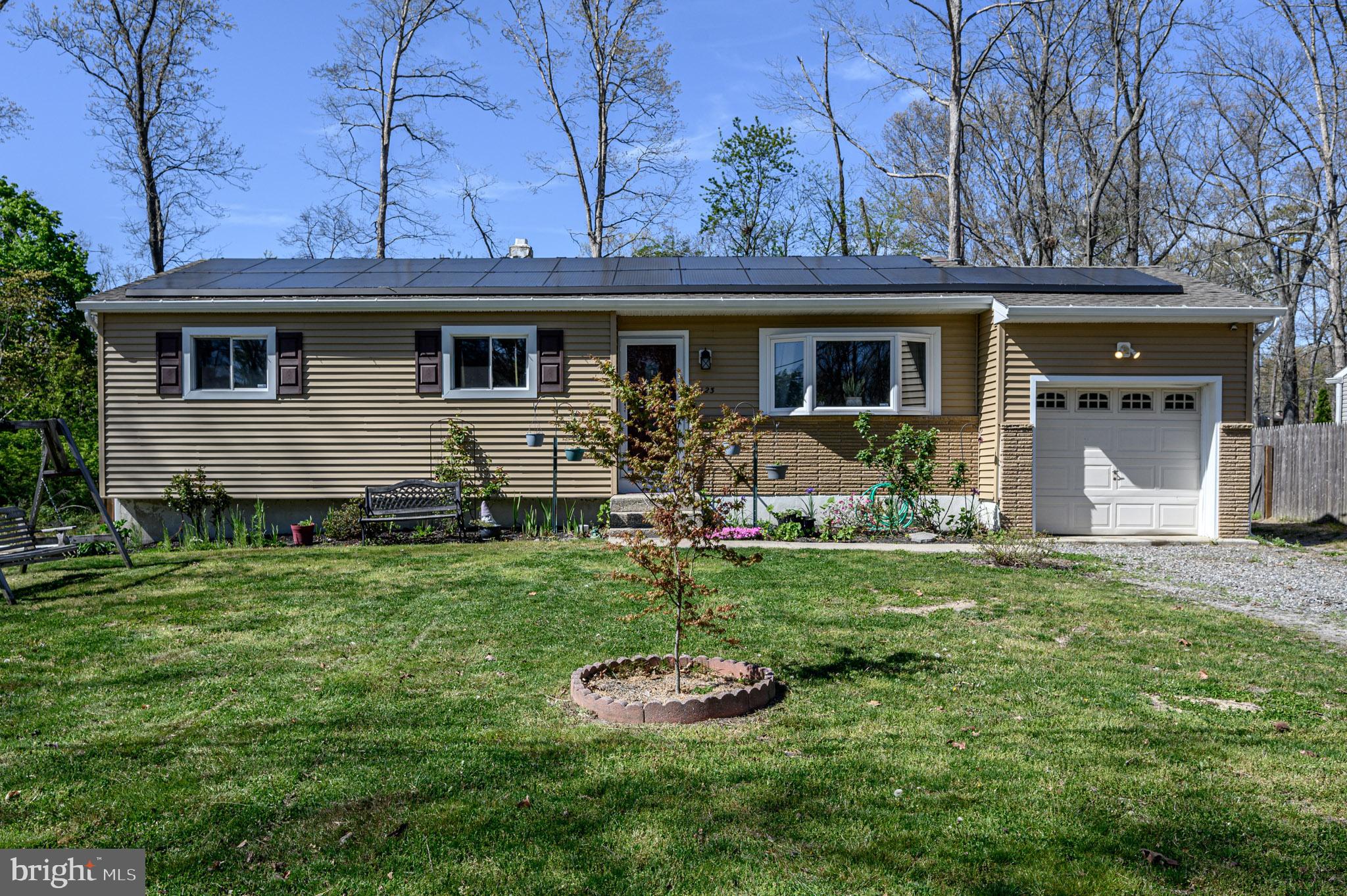 a front view of house with a garden