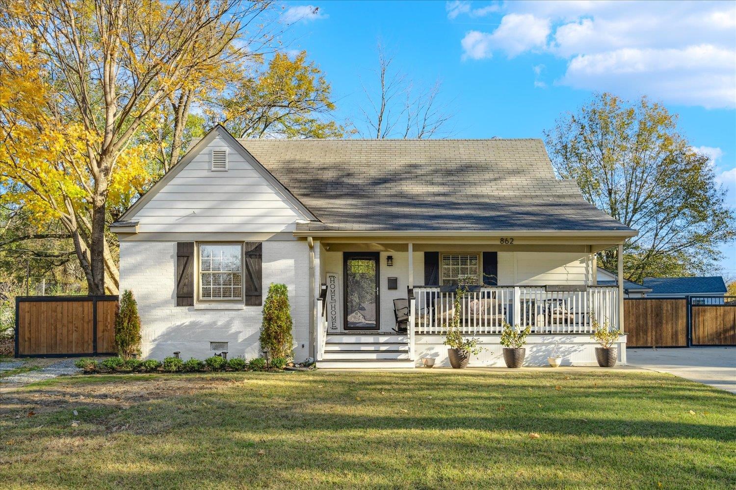 View of front of property with covered porch and a front yard