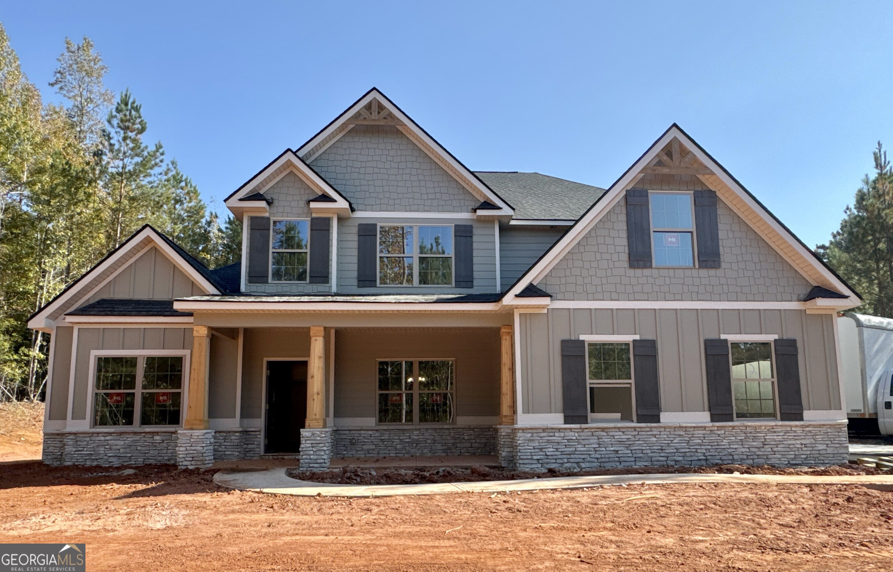 a front view of a house with yard and parking