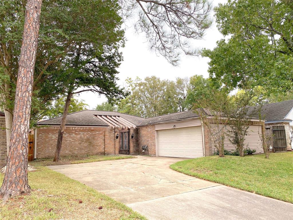 a front view of a house with a garden and trees