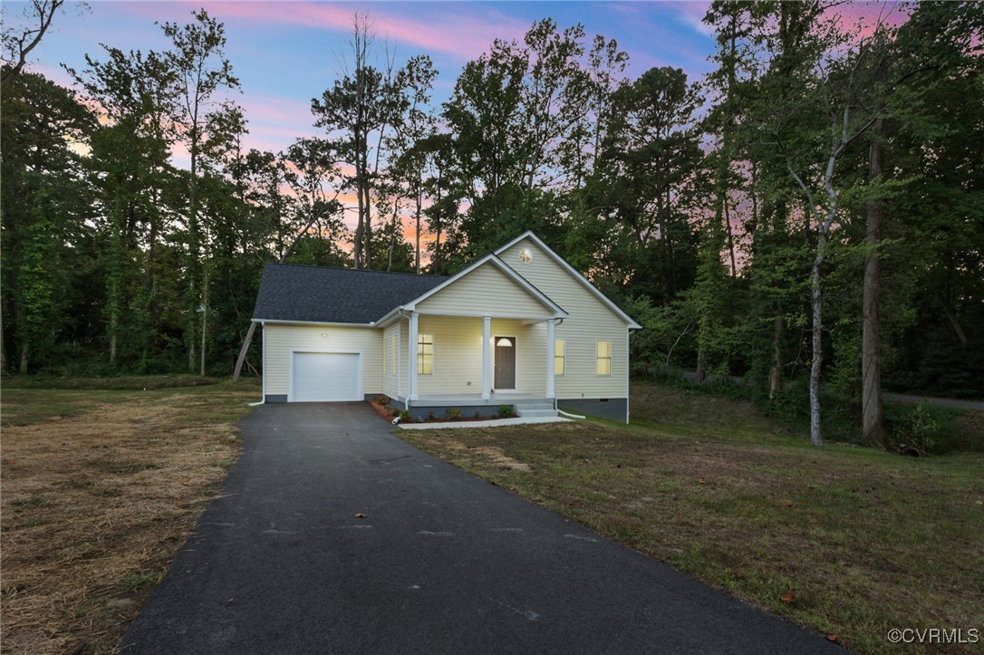 View of front of home featuring a garage and a yar