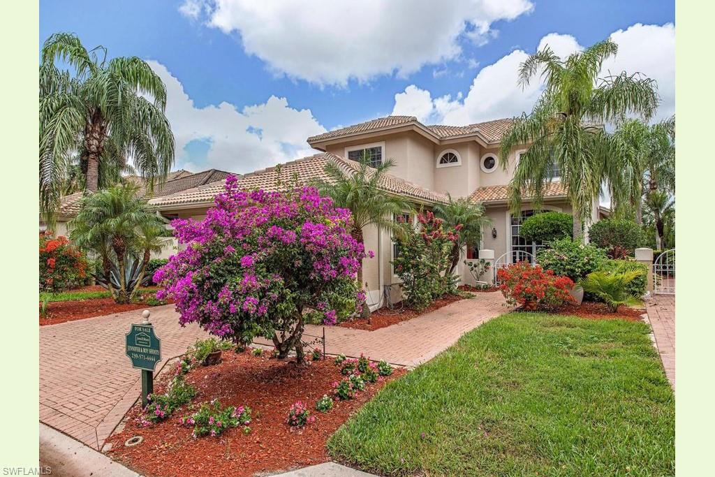 a front view of a house with a big yard and potted plants