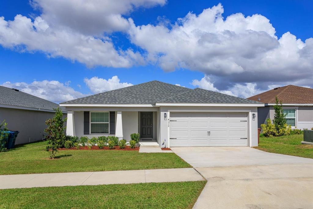 a front view of a house with a yard and garage