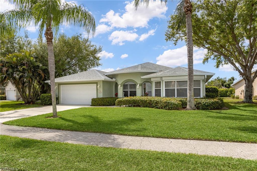 View of front of property featuring a front yard and a garage