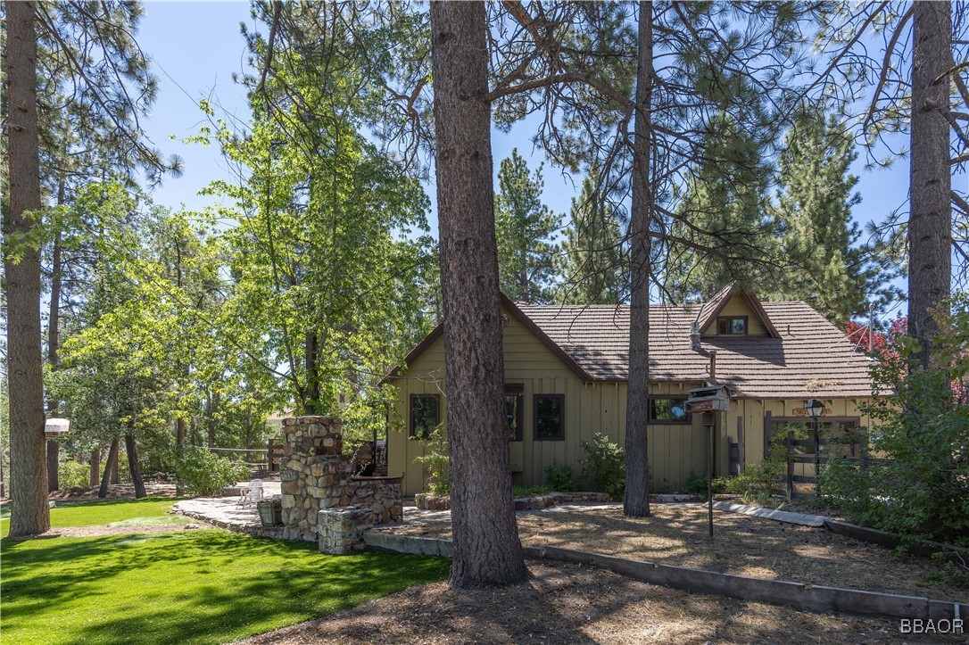 a front view of a house with a yard and tree s