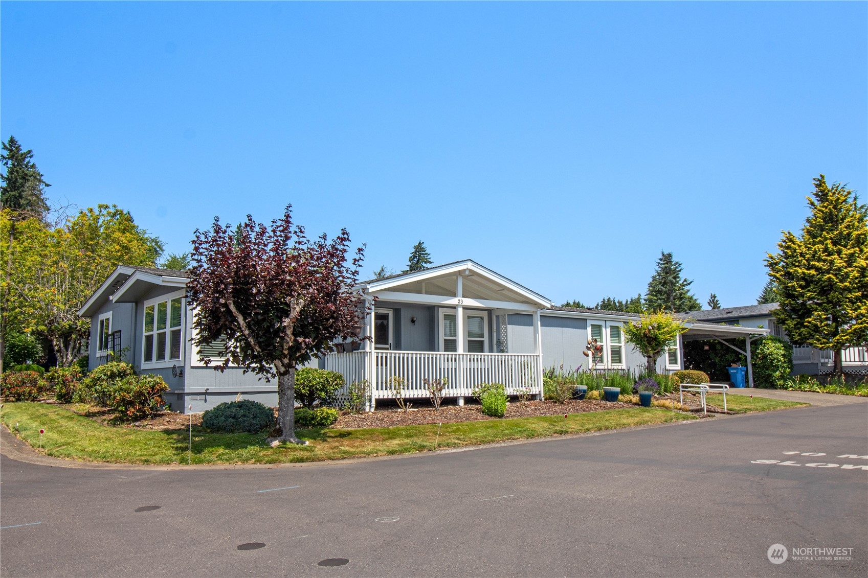 a front view of a house with a yard and potted plants