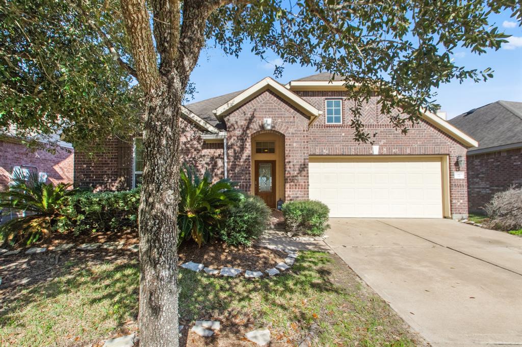 Charming brick home with a welcoming front entrance, two-car garage, beautiful  mature trees and shrubs.