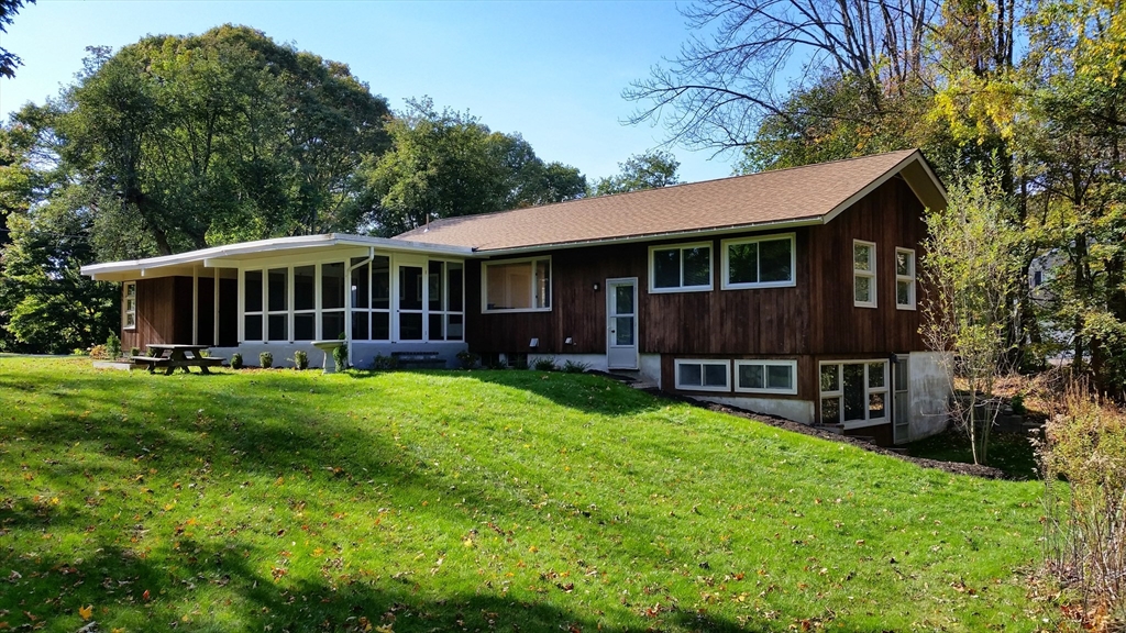 a view of a house with a yard and sitting area