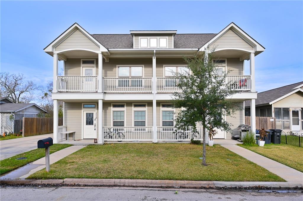 a view of a house with a porch and a yard