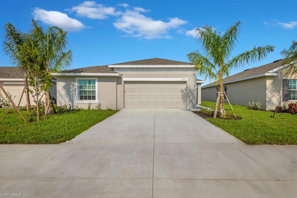 a front view of a house with a yard and a garage