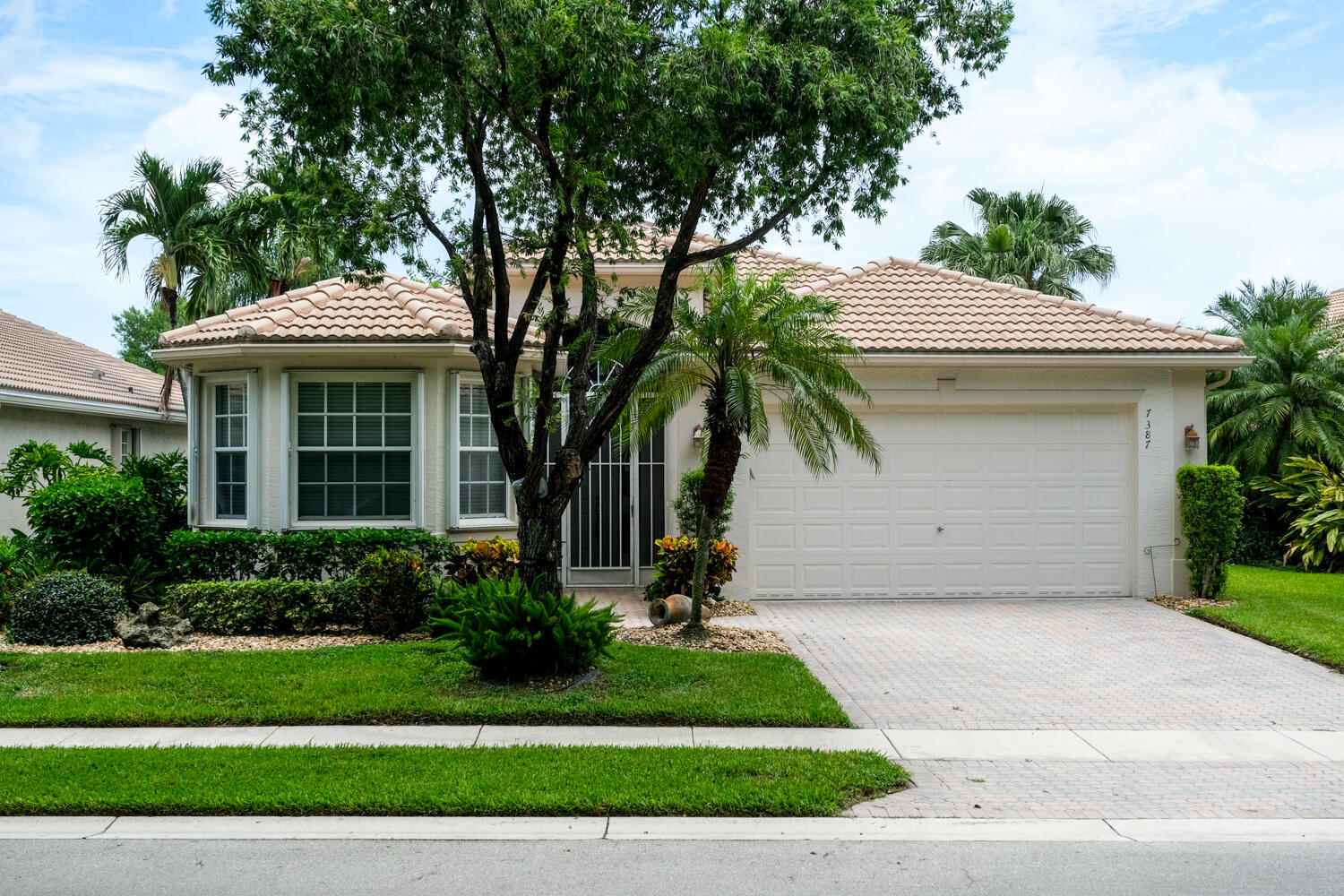 a front view of a house with a garden