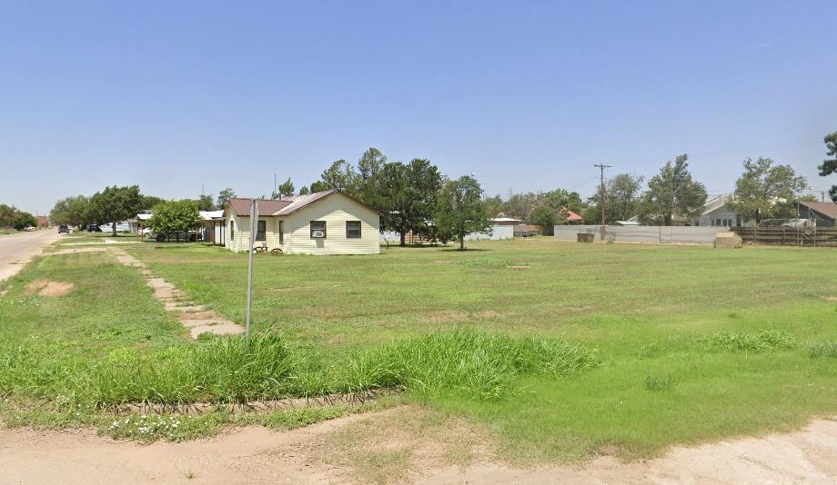 a backyard of a house with lots of green space and lake view in back