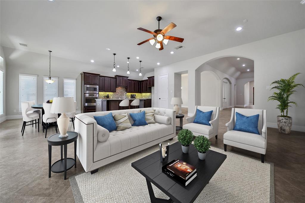 a living room with furniture kitchen view and a chandelier