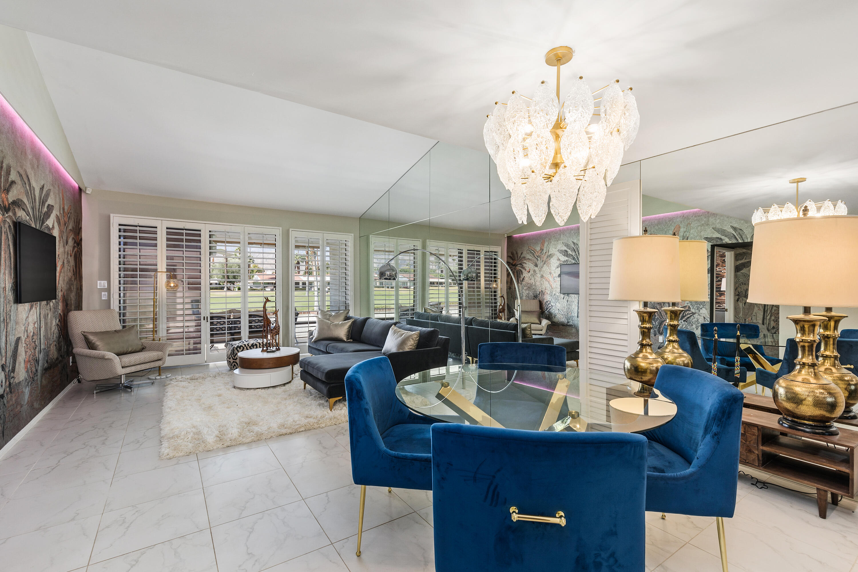 a very nice looking living room with a large dining table and a chandelier