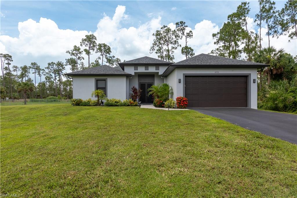 a front view of a house with a yard and garage