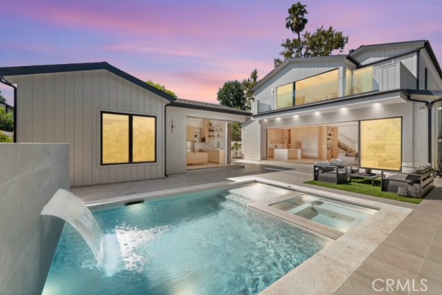 a view of a house with a swimming pool and sitting area