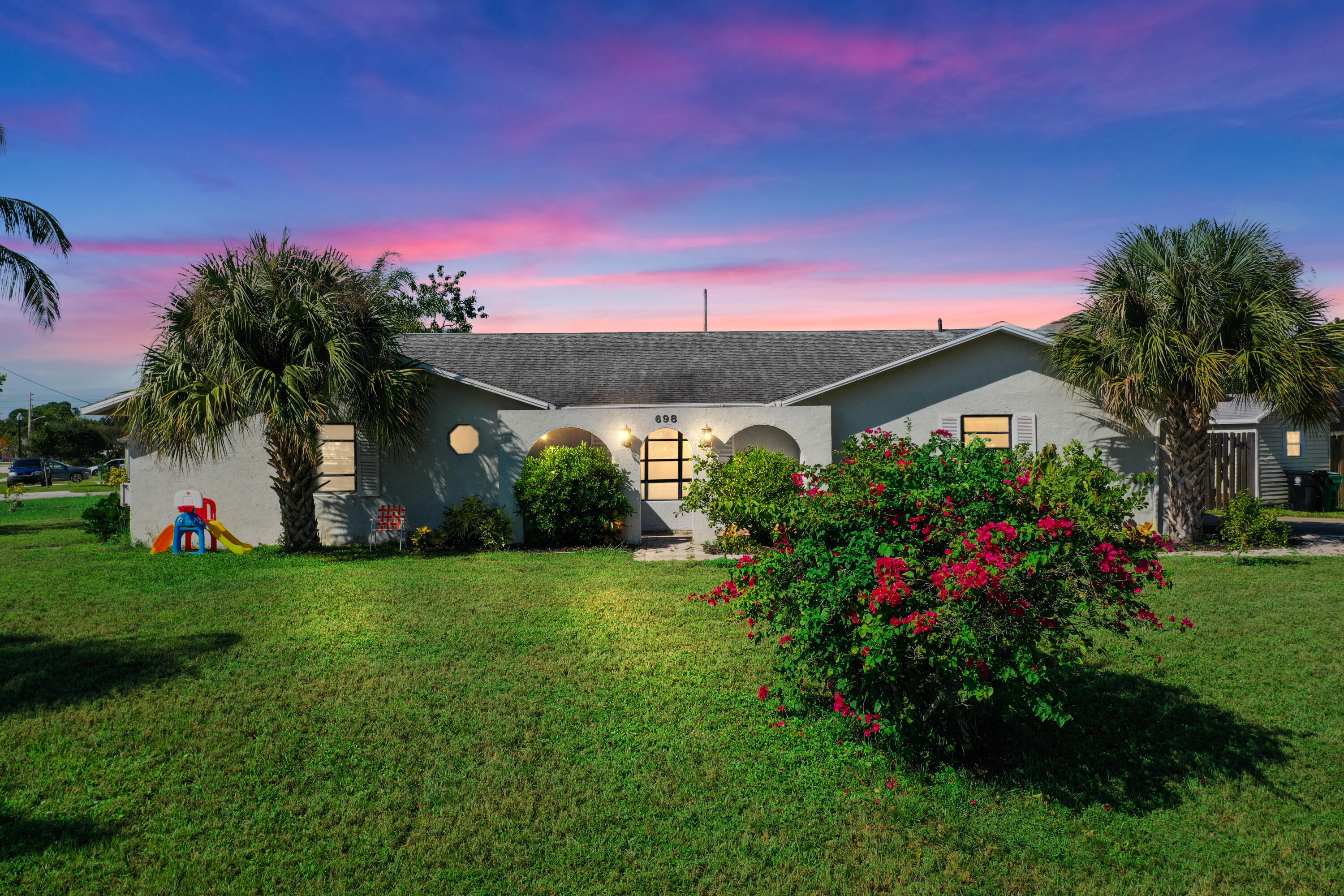 a view of a house with a big yard and potted plants