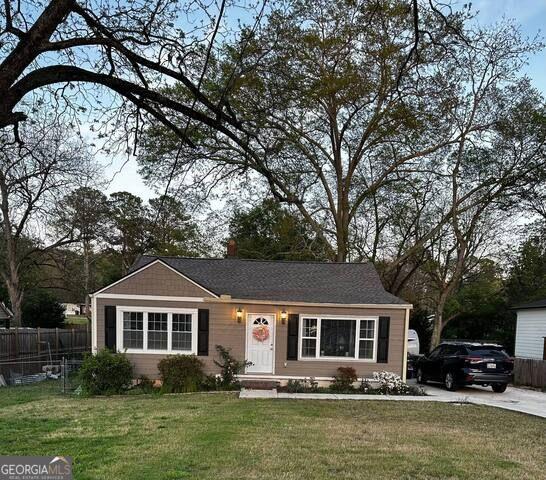 a front view of a house with garden space and swimming pool