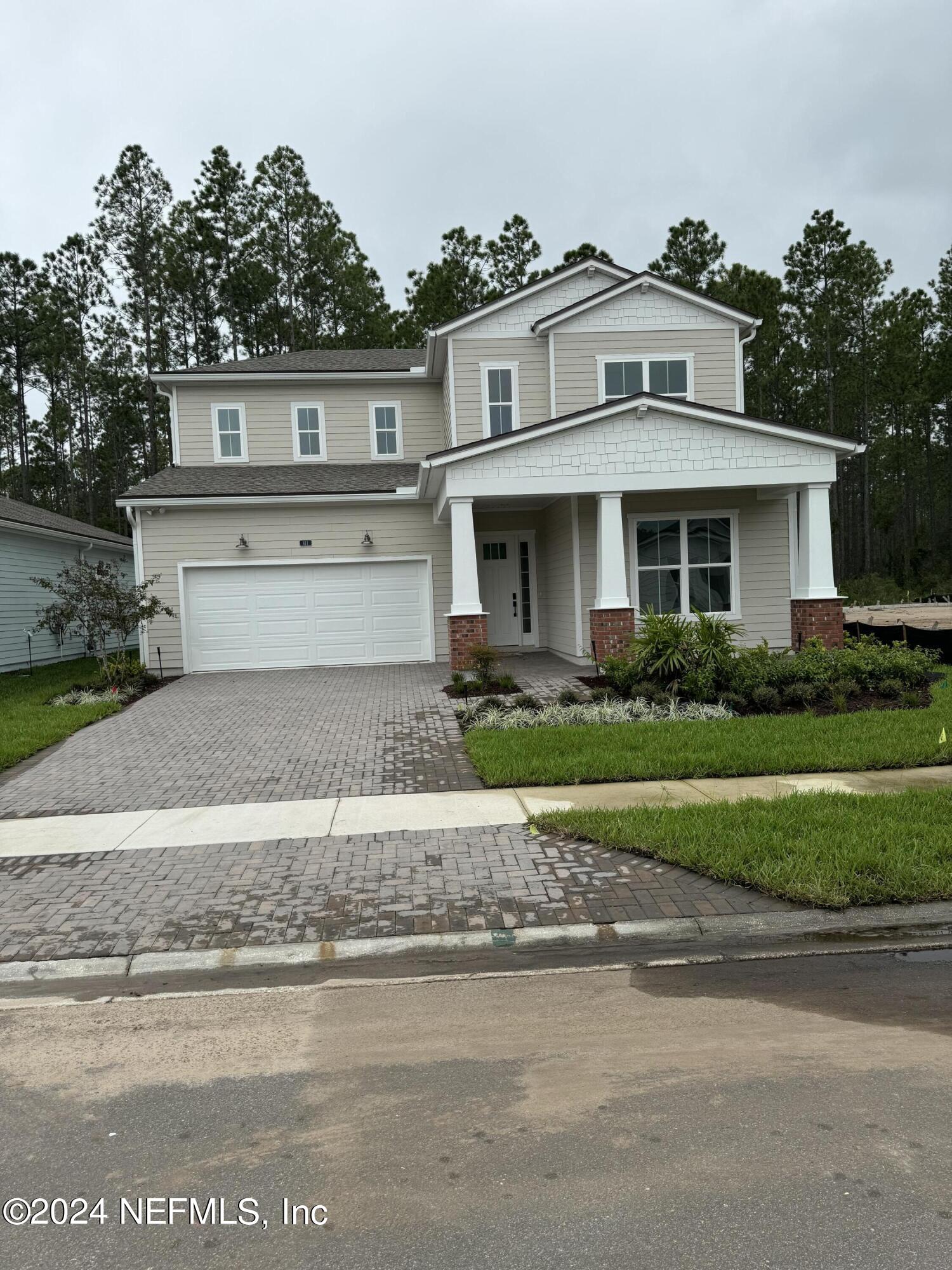 a front view of a house with a yard and a garage