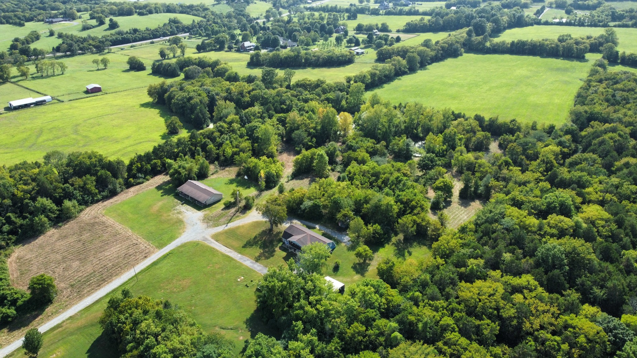 an aerial view of residential houses with outdoor space and trees