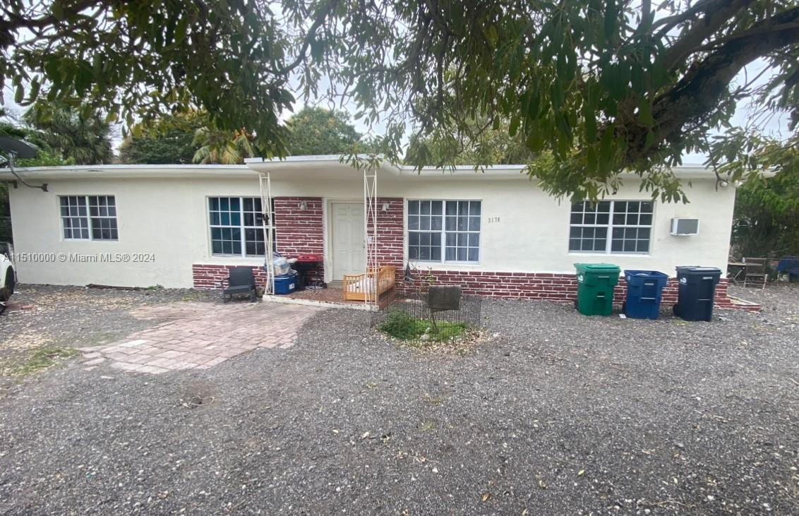 front view of a house with a yard and potted plants