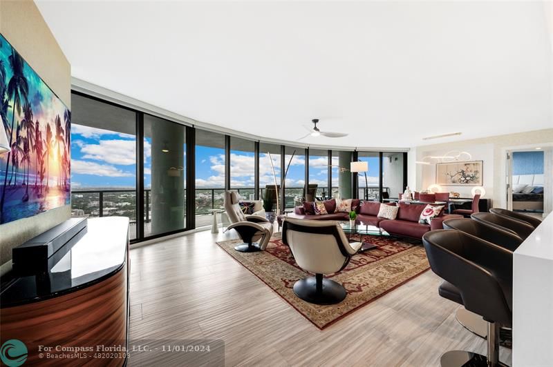 a living room with furniture a large window and a flat screen tv