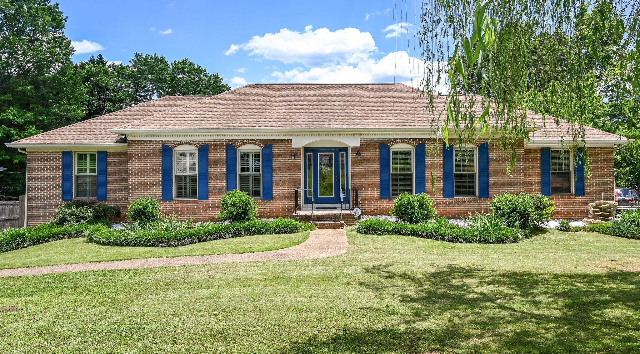 a front view of a house with porch and garden