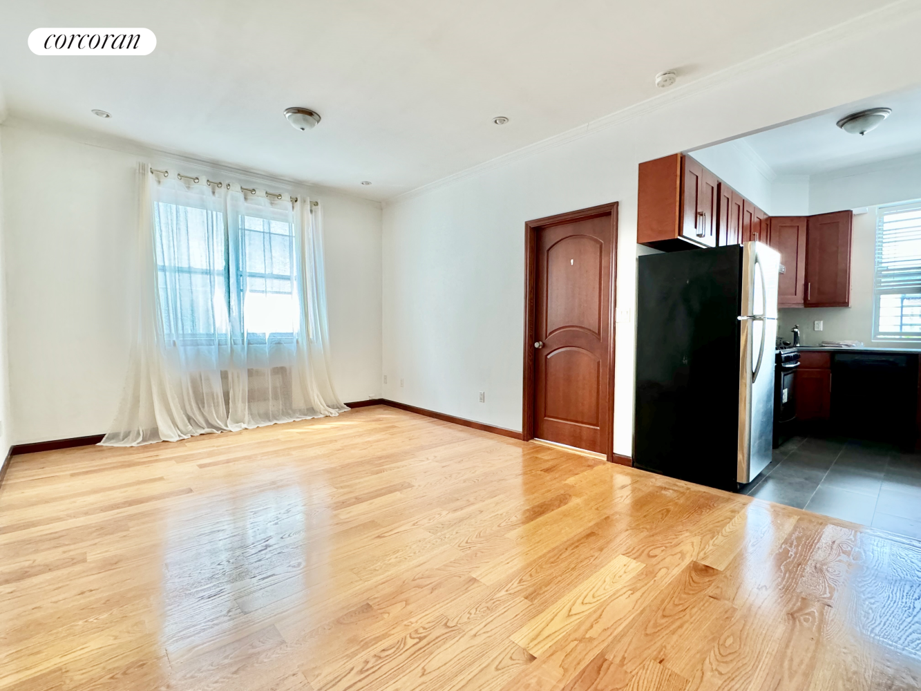 a view of a kitchen with wooden cabinets and refrigerator