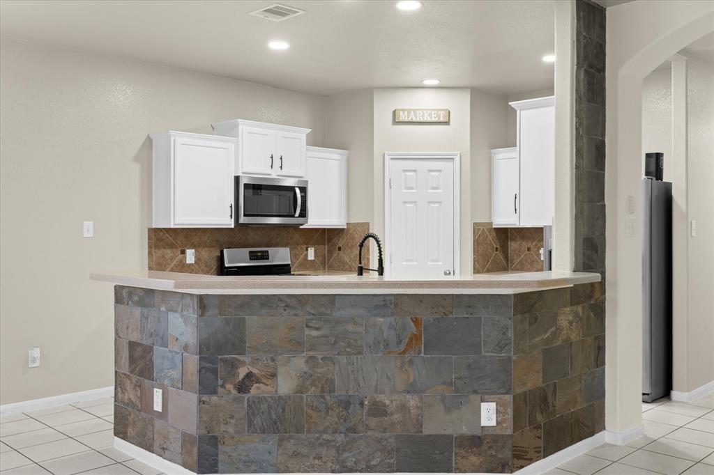 a large kitchen with granite countertop a sink and a stove top oven