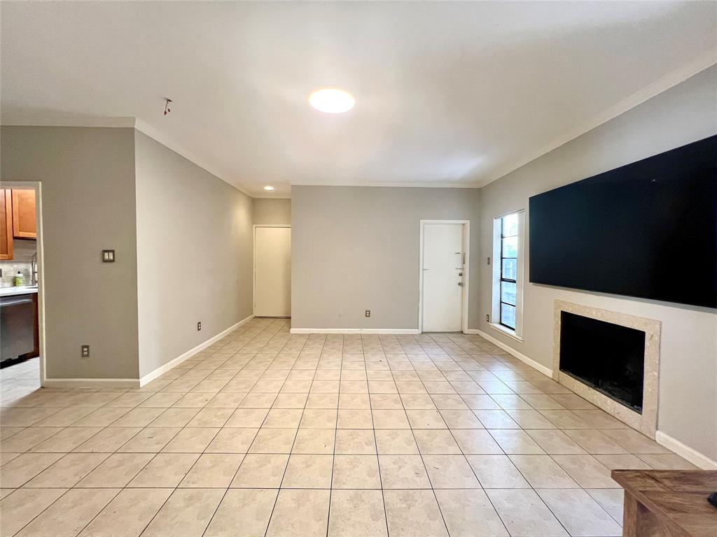 a view of an empty room with a fireplace and a window