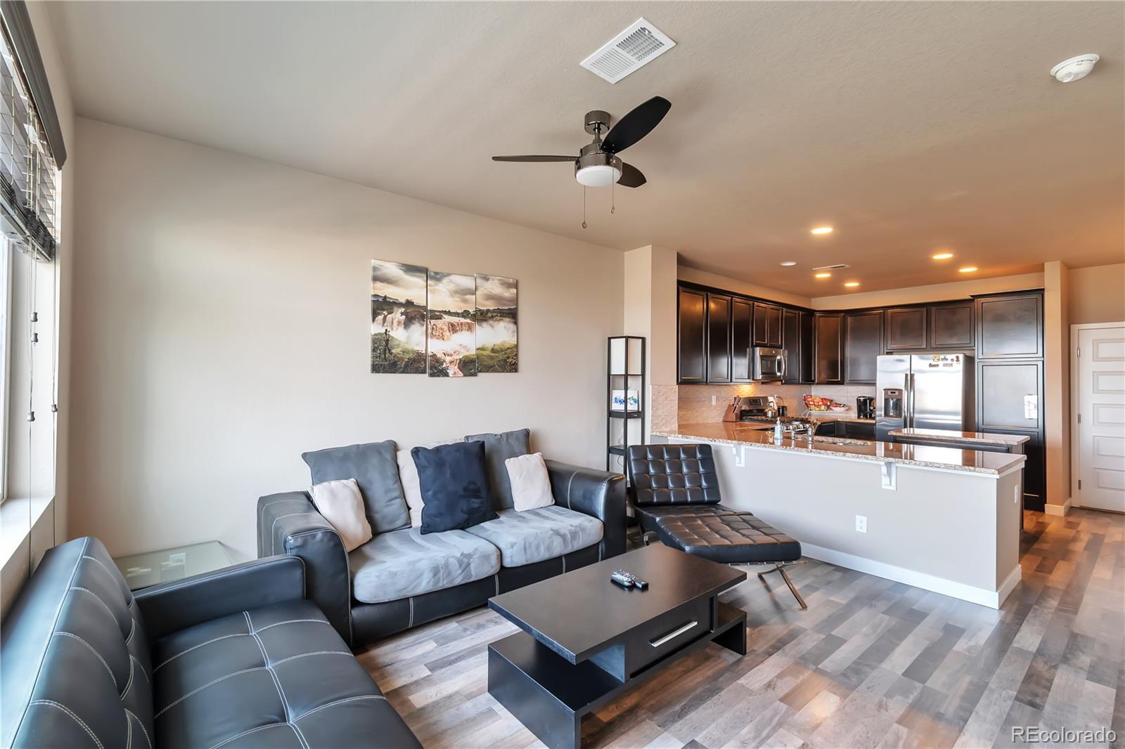 a living room with furniture and kitchen view