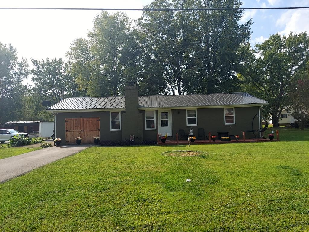 a front view of a house with a garden and trees