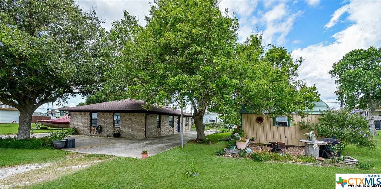 a view of a house with a yard and sitting area