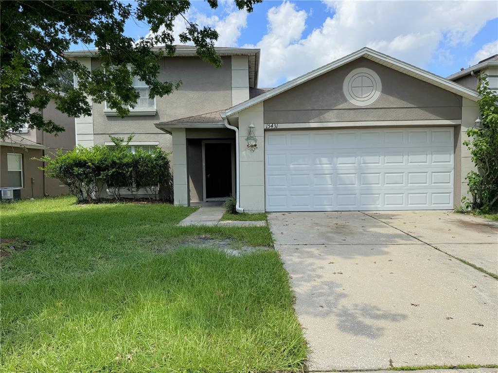 a front view of a house with a yard and garage