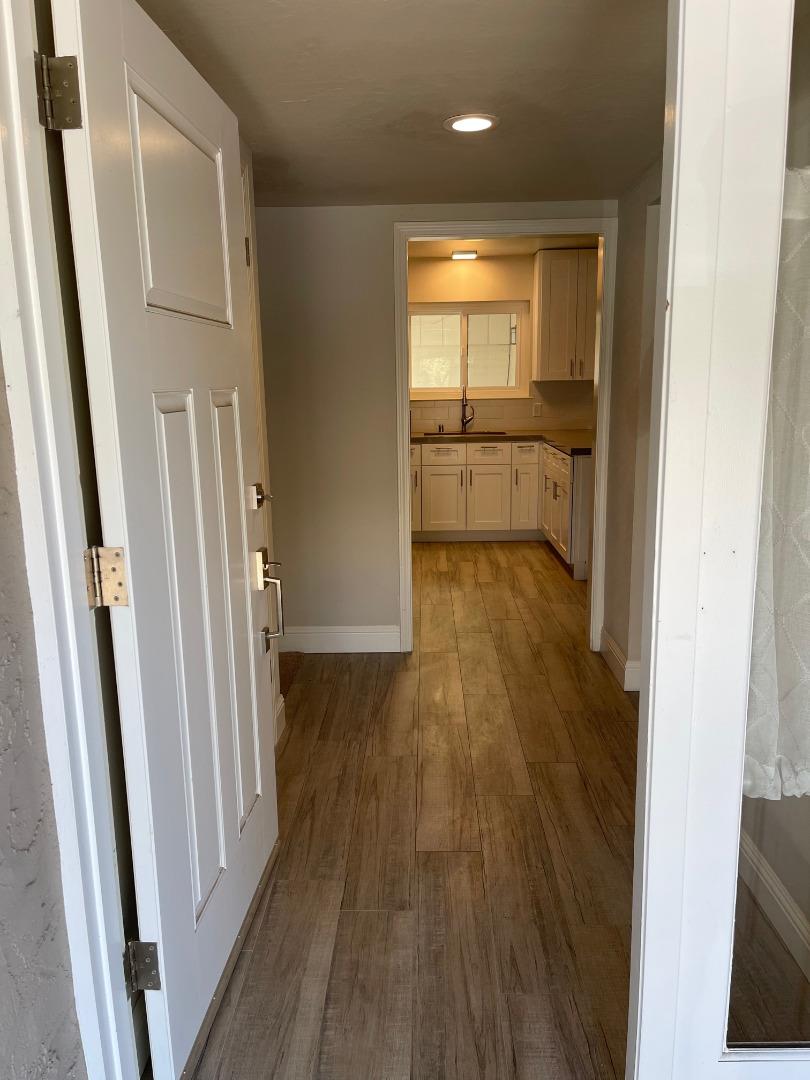 a view of a hallway with wooden floor and a sink