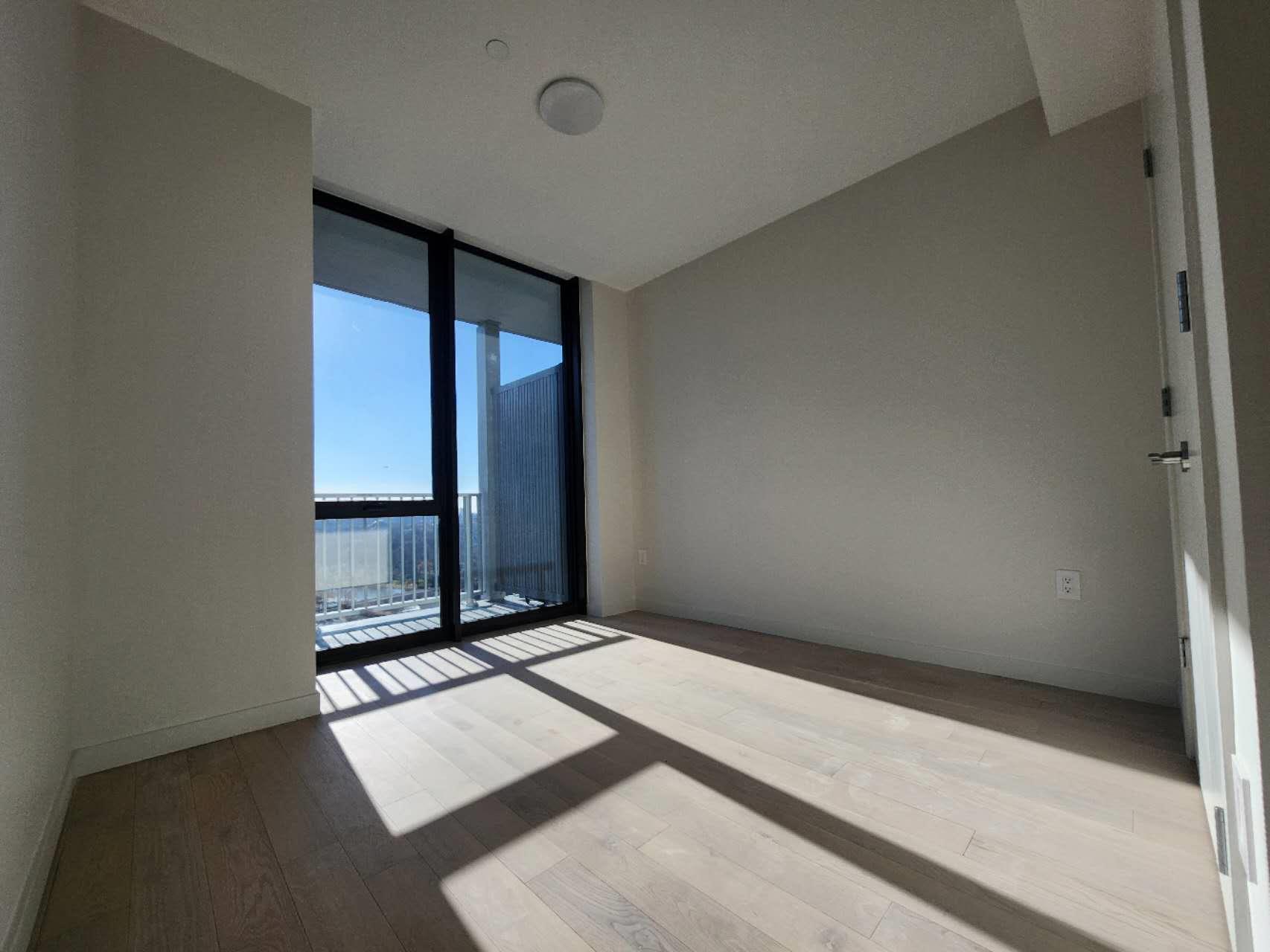 Empty room featuring expansive windows and light hardwood / wood-style floors